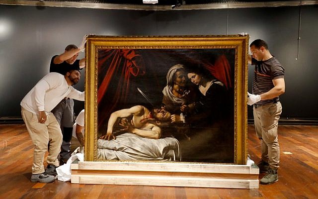 Workers unload a painting believed by some experts to be Caravaggio's 'Judith Beheading Holofernes' for its public presentation at the Drouot auction house in Paris on June 14, 2019 before it goes under the hammer on June 27 in Toulouse, the city where it was discovered five years ago. (FRANCOIS GUILLOT / AFP)