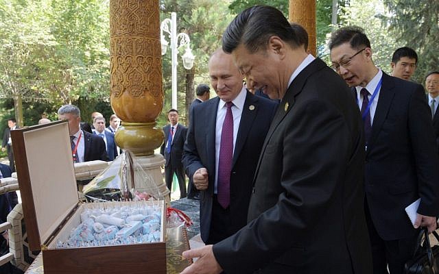 Russian President Vladimir Putin (L) and Chinese President Xi Jinping (R) look at birthday ice creams at the Diaoyutai State Guesthouse in Dushanbe on June 15, 2019. (Alexei Druzhinin / Sputnik / AFP)