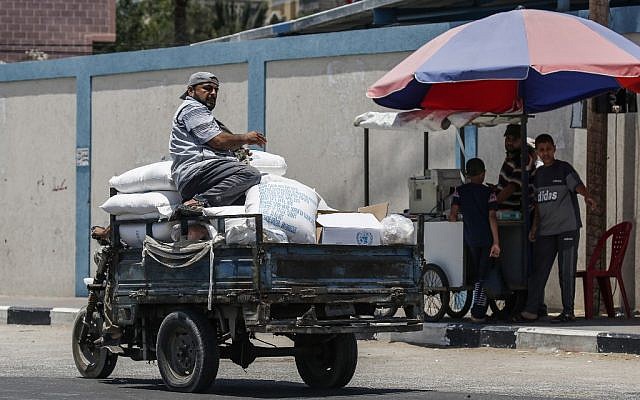 A Palestinian rides on a pickup carrying sacks of food aid provided by UNRWA in the southern Gaza city of Rafah on June 25, 2019. (Said Khatib/AFP)