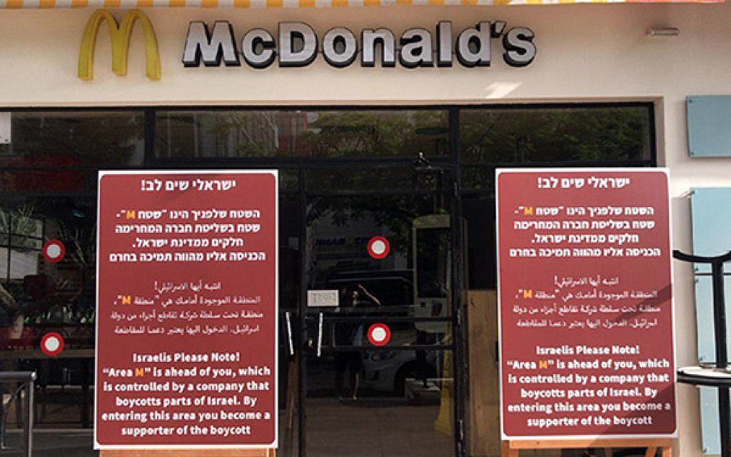 Signs placed in front of McDonald's branches in Tel Aviv on June 4, 2019, accusing the fast-food chain of boycotting West Bank settlements, and urging Israelis to boycott the restaurant giant in return. (Channel 12 screen capture)