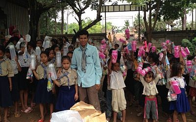 Arun Sothea runs an orphanage in Cambodia with the help of Jewish charities. Here he is shown dispensing supplies to girls in his village of Phum Thom. (Arun Sothea, courtesy)
