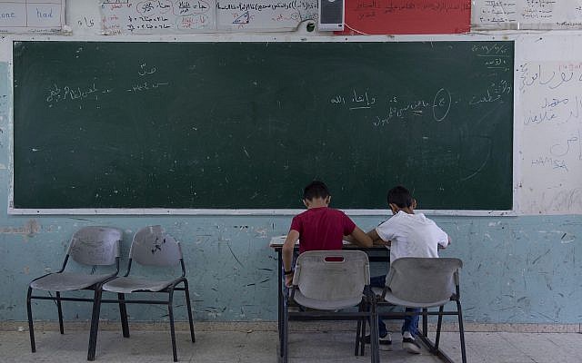 Two Palestinian students take a final exam on the last day of the school year, at the UNRWA Hebron Boys School in the West Bank city of Hebron, May 26, 2019. (AP/Nasser Nasser)