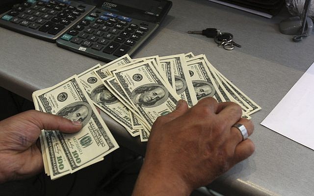 A currency exchange bureau worker, counts US dollars, in downtown Tehran, Iran, June 9, 2011. (AP/Vahid Salemi)