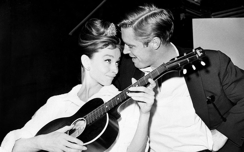 Audrey Hepburn strums a guitar with her costar George Peppard between takes on the set of 'Breakfast at Tiffany's' at a film studio in Hollywood on December 7, 1960. (AP Photo)
