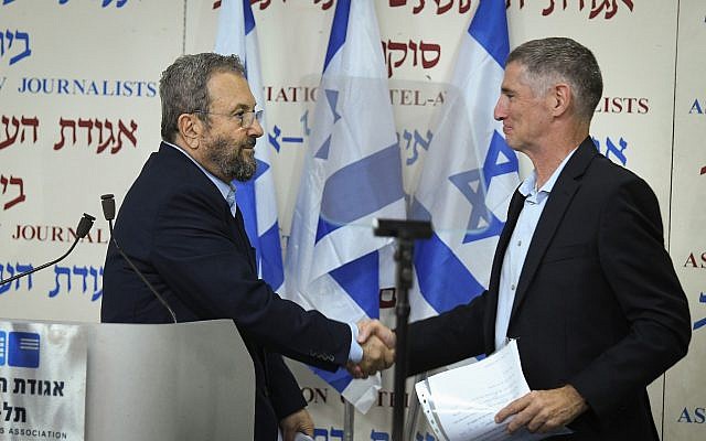Former prime minister Ehud Barak (L) shakes hands with Yair Golan after announcing the formation of a new party at Tel Aviv's Beit Sokolov on June 26, 2019. (Jacob Magid/Times of Israel)