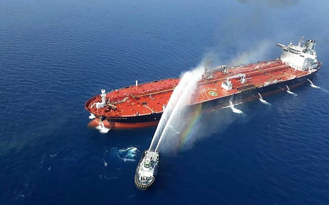 An Iranian navy boat sprays water to extinguish a fire on an oil tanker in the sea of Oman, Thursday, June 13, 2019. (AP Photo/Tasnim News Agency)