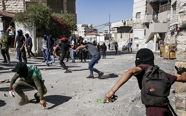 Palestinians throw stones during clashes with Israeli police in Jerusalem’s neighborhood of Issawiya on June 28, 2019, a day after a Palestinian was shot and killed by police during a protest in the same neighborhood. (Hazem Bader/AFP)
