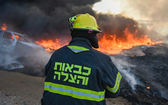 A firefighter works to extinguish a blaze caused by an incendiary device from the Gaza Strip in southern Israel on June 27, 2019. (Fire and Rescue Services)
