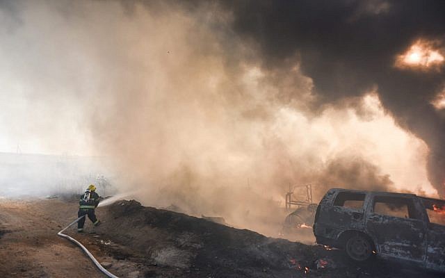 A firefighter works to extinguish a blaze caused by an incendiary device from the Gaza Strip in southern Israel on June 27, 2019. (Fire and Rescue Services)