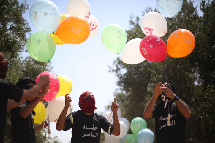 Palestinian youth prepare incendiary balloons, to send to Israel east of Bureij refugee camp, in the Gaza Strip, on May 31, 2019. (Hassan Jedi/ Flash90)