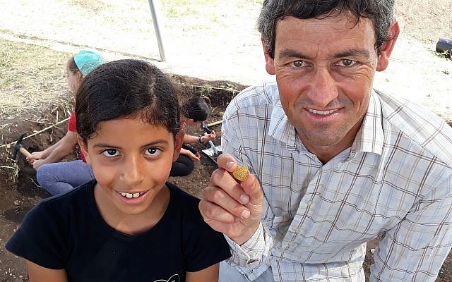 Fourth-grade student Shira Sofer pictured with the ninth-century gold coin she found and archaeologist Achia Cohen-Tavor, May 30, 2019. (Nicole Gutman, Karev Program for Educational Involvement)