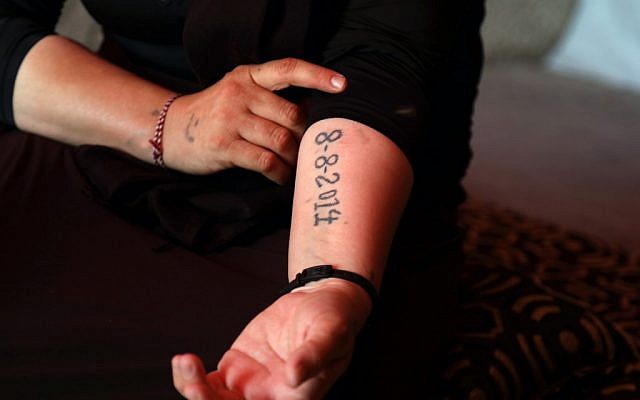An Iraqi Yazidi survivor displays a tattoo bearing the date fighters from the Islamic State group entered the village of Sinjar, at her tent in the Khonke camp for displaced persons in northwestern Iraq on June 24, 2019. (SAFIN HAMED/AFP)