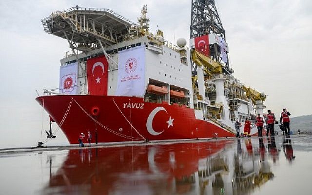 Journalists walk next to the drilling ship 'Yavuz' scheduled to search for oil and gas off Cyprus, at the port of Dilovasi, outside Istanbul, on June 20, 2019. (Bulent Kilic/AFP)