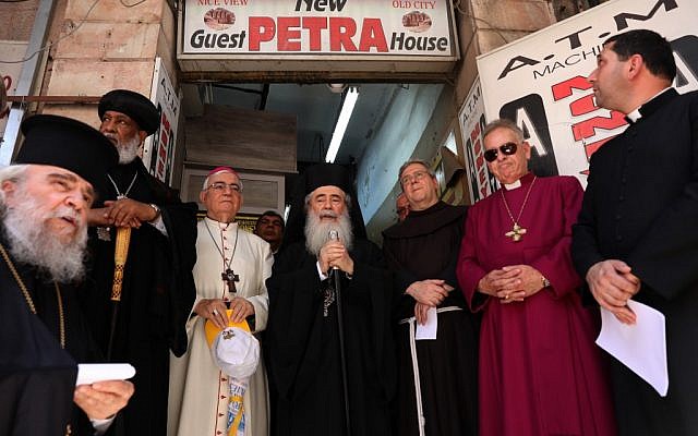 Greek Orthodox Patriarch of Jerusalem Theophilus III, center, together with the Franciscan Custodian of the Holy Land Fr Francesco Patton, center-right, and fellow church leaders from different denominations hold an ecumenical prayer outside the Petra hostel at Jaffa Gate in Jerusalem's Old City on July 11, 2019. (GALI TIBBON/AFP)