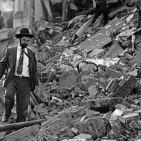 In this photo from July 18, 1994, a man walks over the rubble left after of the Argentinian Israeli Mutual Association (AMIA) building in Buenos Aires after it was targeted in a deadly bombing. (Ali Burafi/AFP)