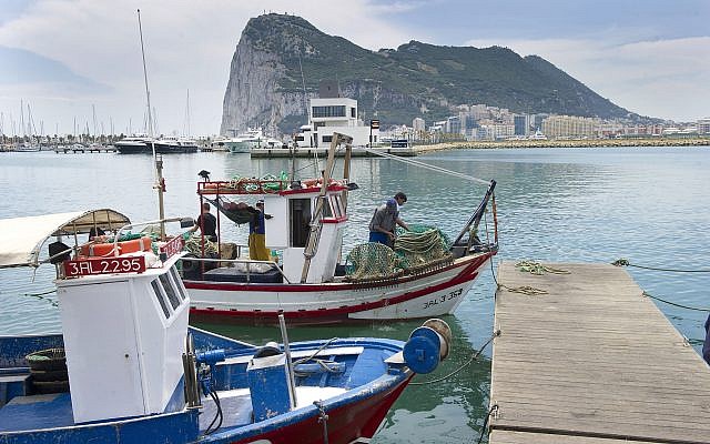 In this file photo taken on May 28, 2012, Spanish fishing boats sit moored in La Linea de Concepcion, Spain, backdropped by the Rock of Gibraltar.  (AP Photo/Marcos Moreno, File)