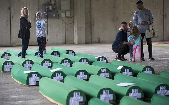 Relatives inspect coffins prepared for burial, in Potocari near Srebrenica, Bosnia, July 10, 2019. The remains of 33 victims of the Srebrenica massacre were buried 24 years after Serb troops overran the eastern Bosnian Muslim enclave of Srebrenica and executed some 8,000 Muslim men and boys, an event international courts have labeled as an act of genocide. (AP Photo/Darko Bandic)