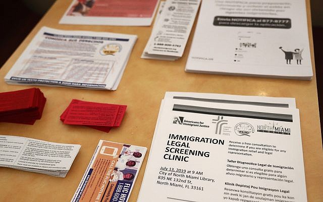 Flyers in English and Spanish are shown stacked at a nearby restaurant before immigration advocates gather them and hand them out, Thursday, July 11, 2019, in the Little Havana neighborhood in Miami. The Trump administration is moving forward with a nationwide immigration enforcement operation this weekend targeting migrant families. (AP Photo/Wilfredo Lee)