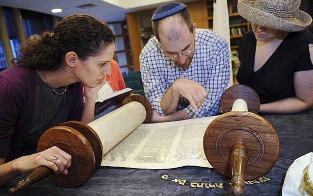 In this July 16, 2010 photo, members of the religious group Minyan Tehillah look at a Torah scroll as they prepare for Shabbat services at Harvard Radcliffe Hillel, in Cambridge, Massachusetts. (AP Photo/Lisa Poole)
