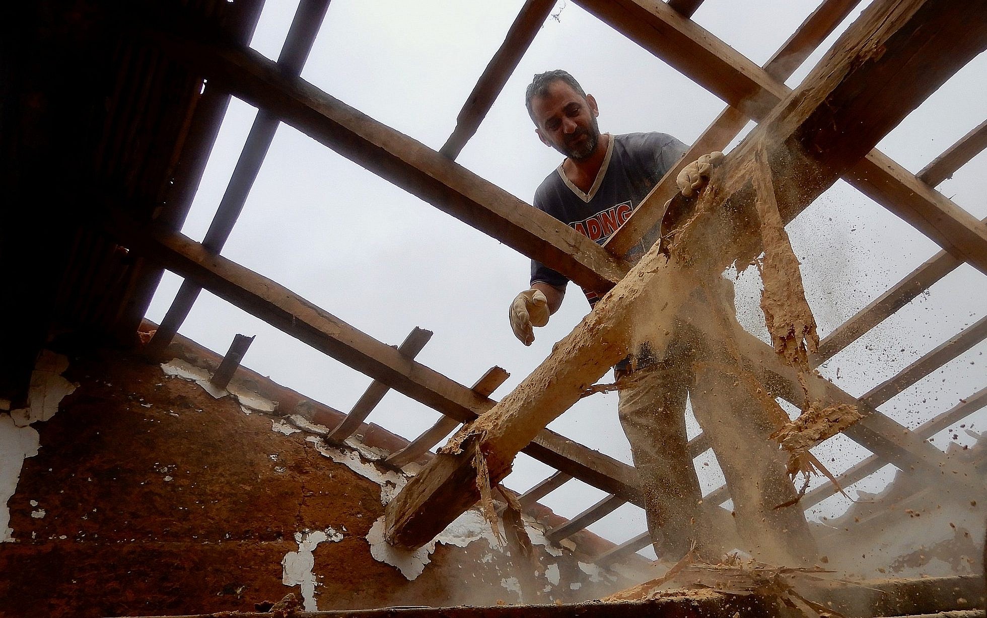 Tamir Burstein Nevo removing the the termite-ravaged roof of a traditional Portuguese farmhouse in southern Portugal on May 9, 2019. (Melanie Lidman/Times of Israel)