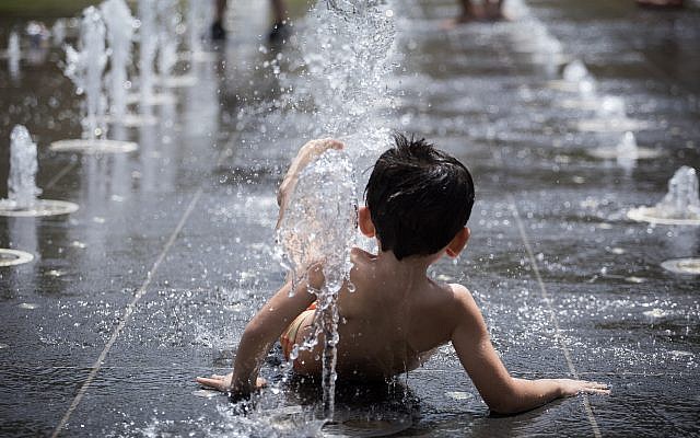 Young children play in the splash fountain at Teddy Park in Jerusalem as temperatures soar in a nationwide heat wave on July 17, 2019. (Hadas Parush/Flash90)
