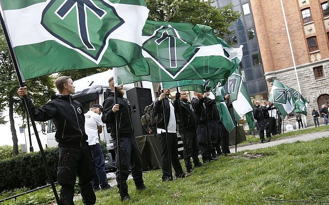 Illustrative: Supporters of the neo-Nazi Nordic Resistance Movement hold flags during a demonstration at the Kungsholmstorg square in Stockholm, Sweden on August 25, 2018. (Fredrik Persson/Getty Images/AFP)