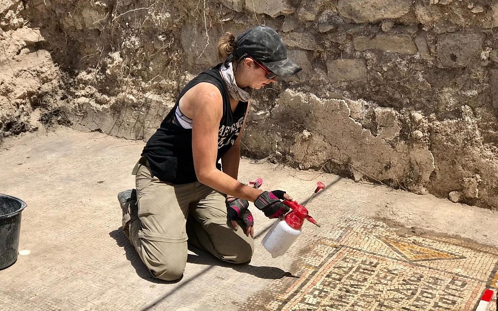 Area supervisor Jessica Rentz cleans a mosaic at the 'Burnt Church' at the Hippos-Sussita Excavation Project at the Susita National Park, summer 2019. (courtesy)