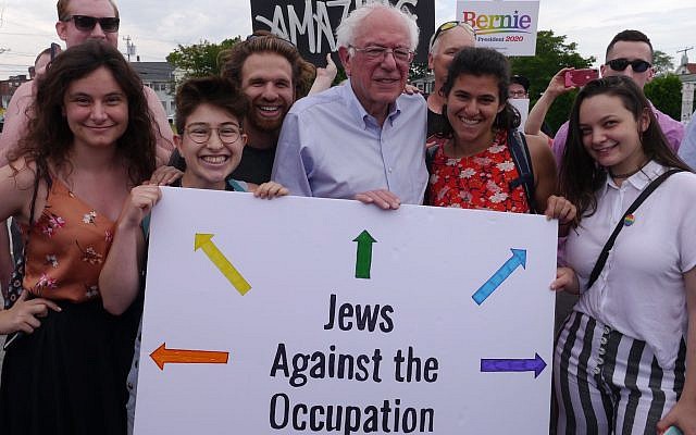 Illustrative: Vermont Senator Bernie Sanders poses with IfNotNow activists in New Hampshire, including University of Michigan student Becca Lubow on the far left, and holds a sign that reads ‘Jews Against Occupation.’ (Courtesy/IfNotNow)