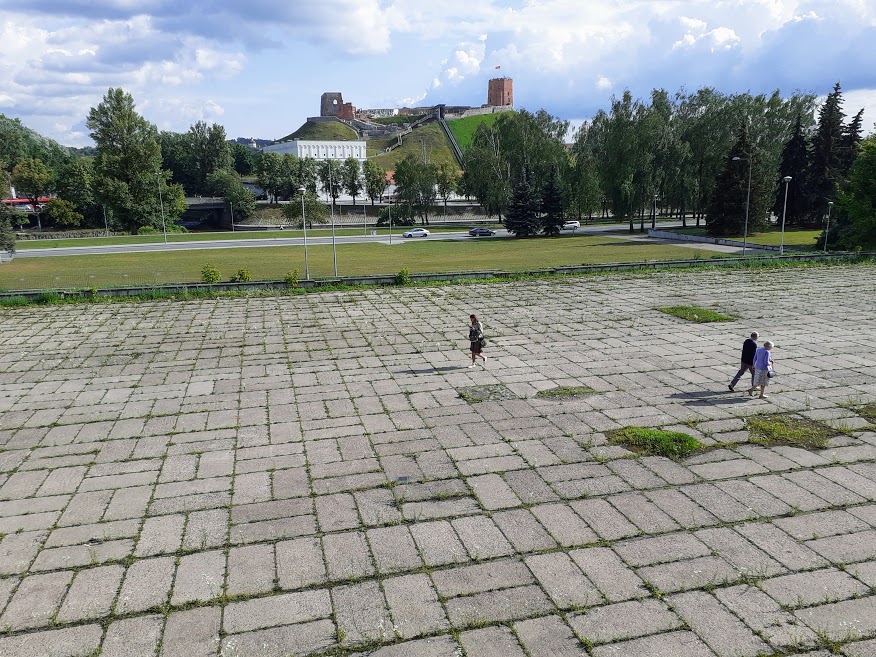 People walk on where decades ago stood an ancient Jewish cemetery, near an abandoned and soon-to-be renovated sports complex that the Soviets built in the middle of the cemetery, in central Vilnius, Lithuania, July 2019 (Raphael Ahren/TOI)