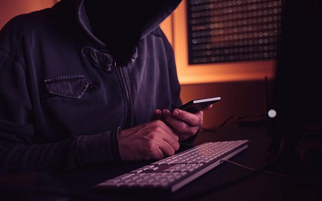 Illustrative image of a computer hacker using a smartphone. (stevanovicigor; iStock by Getty Images)