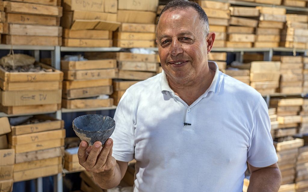 Dr. Hamoudi Khalaily, Antiquities Authority Excavation director at the Motza site, holding a bowl from the Neolithic Period. (Yaniv Berman, Israel Antiquities Authority)