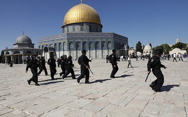 Israeli security forces walk past the Dome of the Rock shrine, as they arrive at the Temple Mount compound in the Old City of Jerusalem on August 11, 2019, after clashes broke out during the overlapping Jewish and Muslim holidays of Eid al-Adha and Tisha B'Av. (Ahmad Gharabli/AFP)