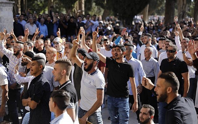 Illustrative: Palestinian Muslims shout at Israeli security forces (unseen) in the Temple Mount in the Old City of Jerusalem on August 11, 2019. (Ahmad Gharabli/AFP)