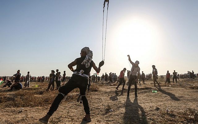 A Palestinian uses a slingshot to hurl stones during clashes with Israeli forces near the border with Israel in the eastern Gaza Strip on August 16, 2019. (MAHMUD HAMS / AFP)