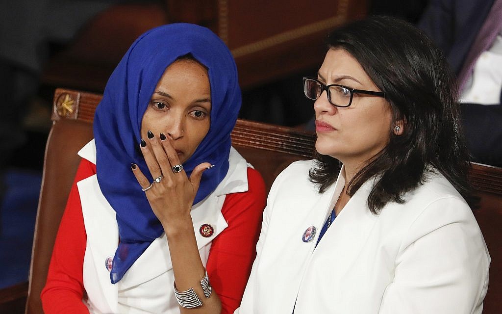 Rep. Ilhan Omar, Democrat of Minnesota left, joined at right by Rep. Rashida Tlaib, Democrat of Michigan, listens to US President Donald Trump's State of the Union speech, at the Capitol in Washington, Feb. 5, 2019. (AP Photo/J. Scott Applewhite)