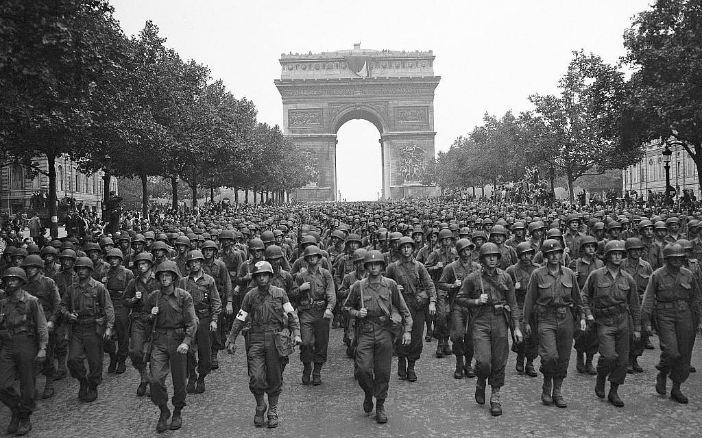 US soldiers of Pennsylvania's 28th Infantry Division march along the Champs Elysees, the Arc de Triomphe in the background, on Aug. 29, 1944, four days after the liberation of Paris, France (AP Photo/Peter J. Carroll)