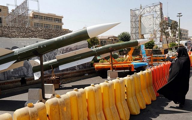 An Iranian woman looks at Taer-2 missile during a street exhibition by Iran's army and paramilitary Revolutionary Guard celebrating 'Defense Week' marking the 39th anniversary of the start of 1980-88 Iran-Iraq war, at the Baharestan Square in Tehran, on September 26, 2019. (Stringer/AFP)