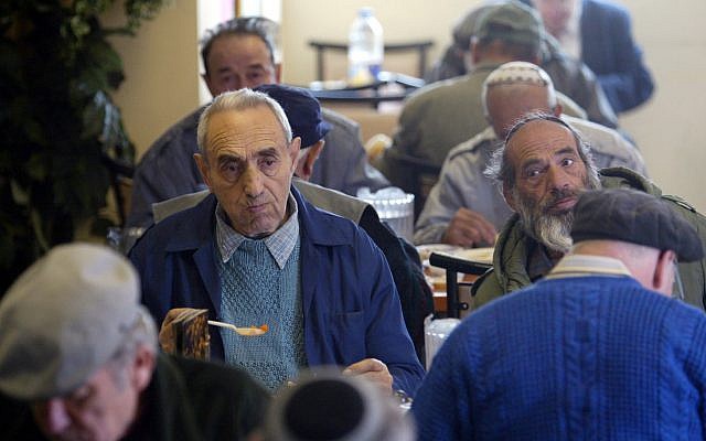 People eat a free meal at the Meir Panim soup kitchen in Jerusalem, in this Monday Dec. 2, 2002 file photo. (AP Photo/Lefteris Pitarakis, file)