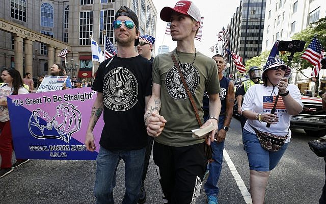 Peter Brown, center left, and Mark Hutt, center right, who said they are engaged to be married, hold hands as they march with others in the Straight Pride Parade in Boston, Saturday, August 31, 2019. (AP Photo/Michael Dwyer)