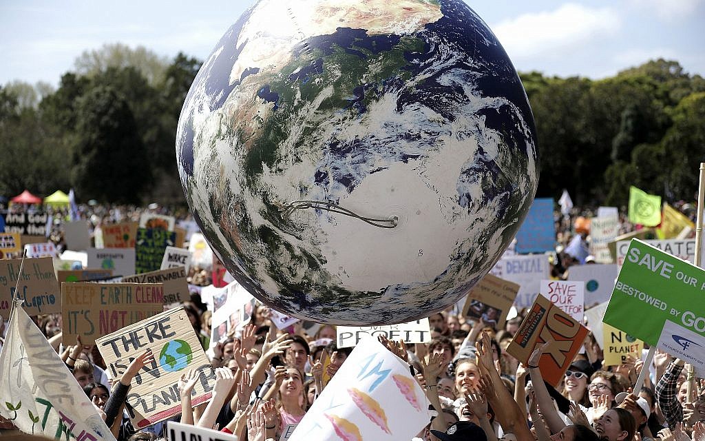 A large inflatable globe is bounced through the crowd as thousands of protesters, many of them school students, gather in Sydney, September 20, 2019, calling for action to guard against climate change. (AP Photo/Rick Rycroft)