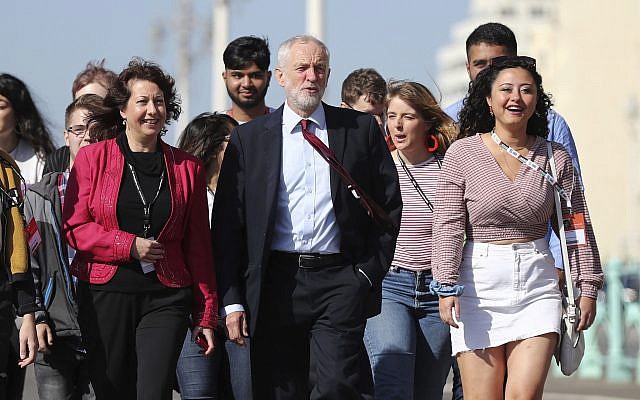 Labour Party leader Jeremy Corbyn, walking along the promenade, arrives for the Labour Party Conference at the Brighton Centre in Brighton, England, September 21, 2019. (Gareth Fuller/PA via AP)