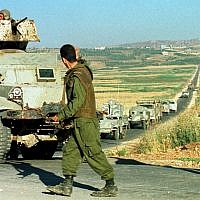 Two militiamen of the Israeli-backed South Lebanon Army direct a convoy of armored vehicles in southern Lebanon, June 3, 1999. (Butros Wanna/AP)