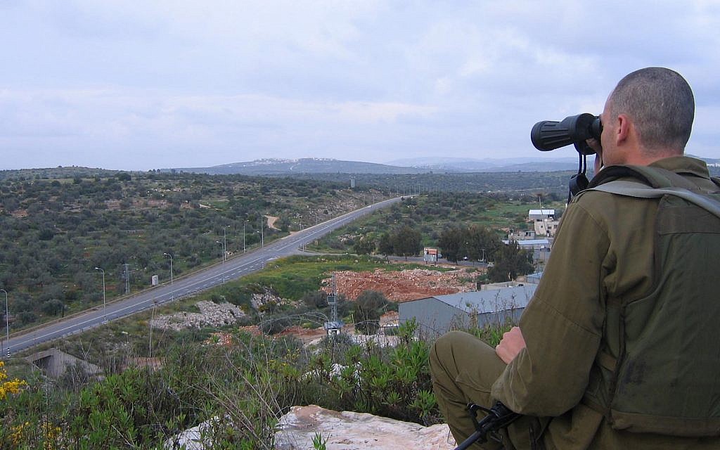 An IDF soldier surveys the area around the village of Azun near the West Bank city of Qalqilya, April 2007. (Roy Sharon/Flash90)
