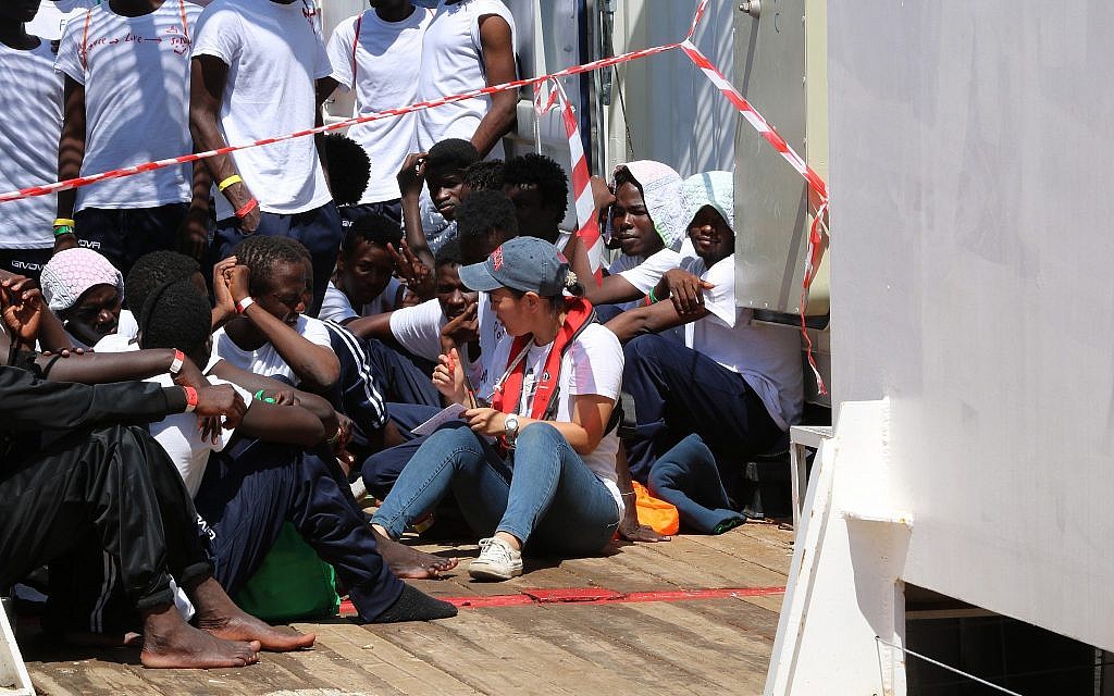 A rescue worker sits with refugees aboard the Ocean Viking, August 2019. (Hannah Wallace Bowman/SOS Mediterranee)