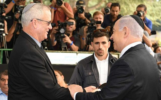 Prime Minister Benjamin Netanyhu (R) and Blue and White party leader Benny Gantz shaking hands during a memorial for former president Shimon Peres in Jerusalem, September 19, 2019. (GPO)