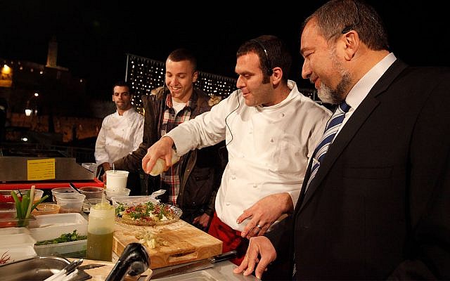 Avigdor Liberman and his son Amos cook with a chef at a food festival held in Jerusalem, March 29, 2011. (Miriam Alster/Flash90)