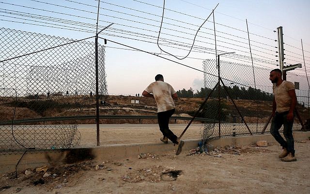 Illustrative: Palestinians illegally cross the border fence into Israel on the outskirts of the West Bank city of Hebron, August 6, 2019. (Wisam Hashlamoun/Flash90)