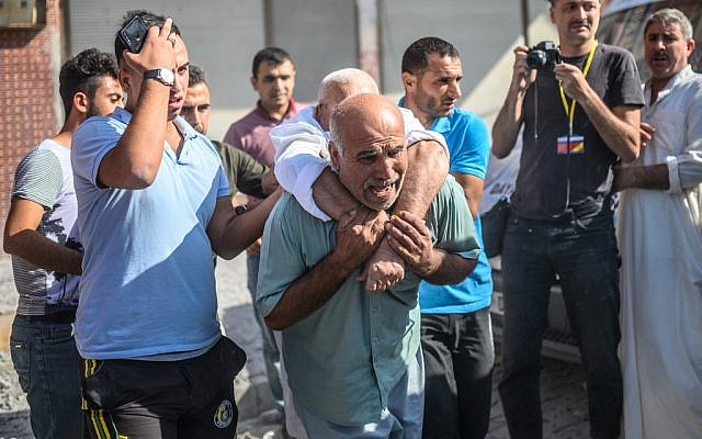 An elderly man is evacuated from a building in Akcakale, a town near the Turkish border with Syria, on October 13, 2019, after it was hit by a rocket reported to be fired from within Syria. (Photo by BULENT KILIC / AFP)