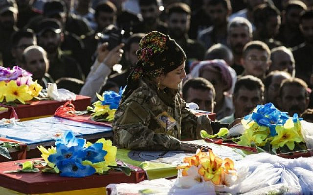 Mourners attend the funeral of five Syrian Democratic Forces’ fighters killed in battles against Turkey-led forces in the flashpoint town of Ras al-Ain along the border, on October 14, 2019 in the Syrian Kurdish town of Qamishli. (Photo by Delil SOULEIMAN / AFP)
