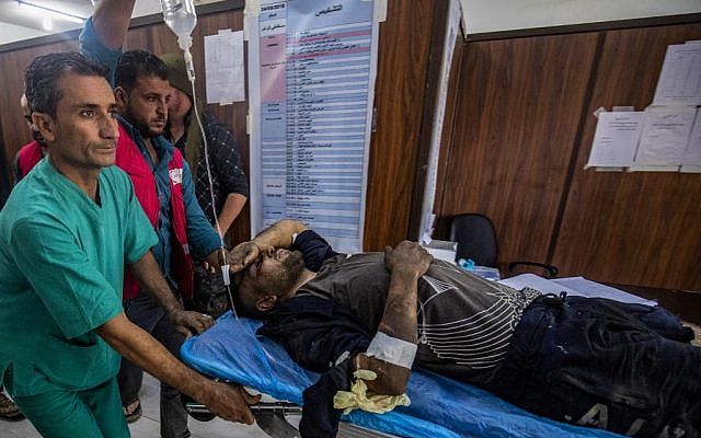 A man who was injured during the ongoing Turkish offensive against Kurdish-controlled areas of northeastern Syria lies at a hospital in Tal Tamr, near the Syrian Kurdish town of Ras al-Ain, October 18, 2019. (Delil Souleiman/AFP)